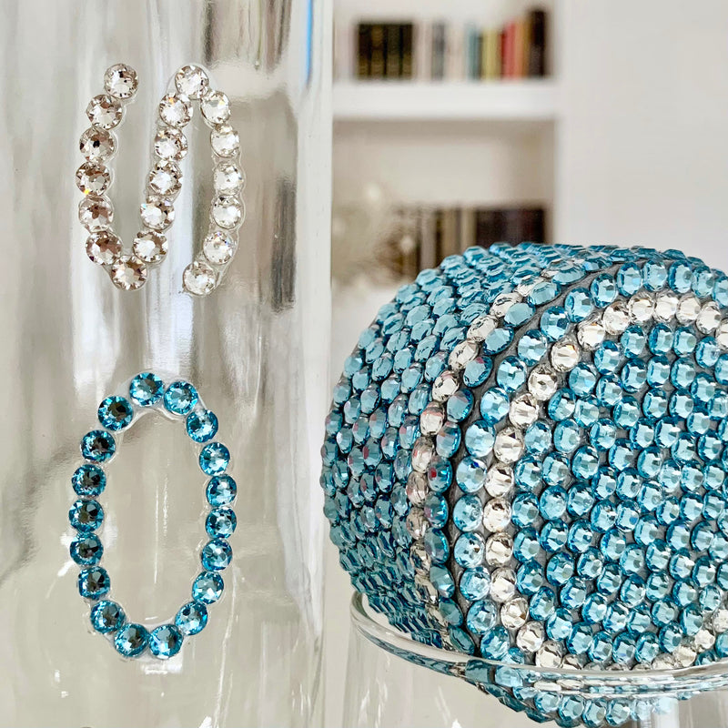 Close-up of handmade WaterGlam Voss bottle lid decorated with sparkling blue and clear Preciosa crystals