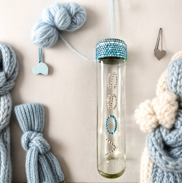 Handmade WaterGlam Voss glass bottle adorned with sparkling blue Preciosa crystals on the lid and lettering